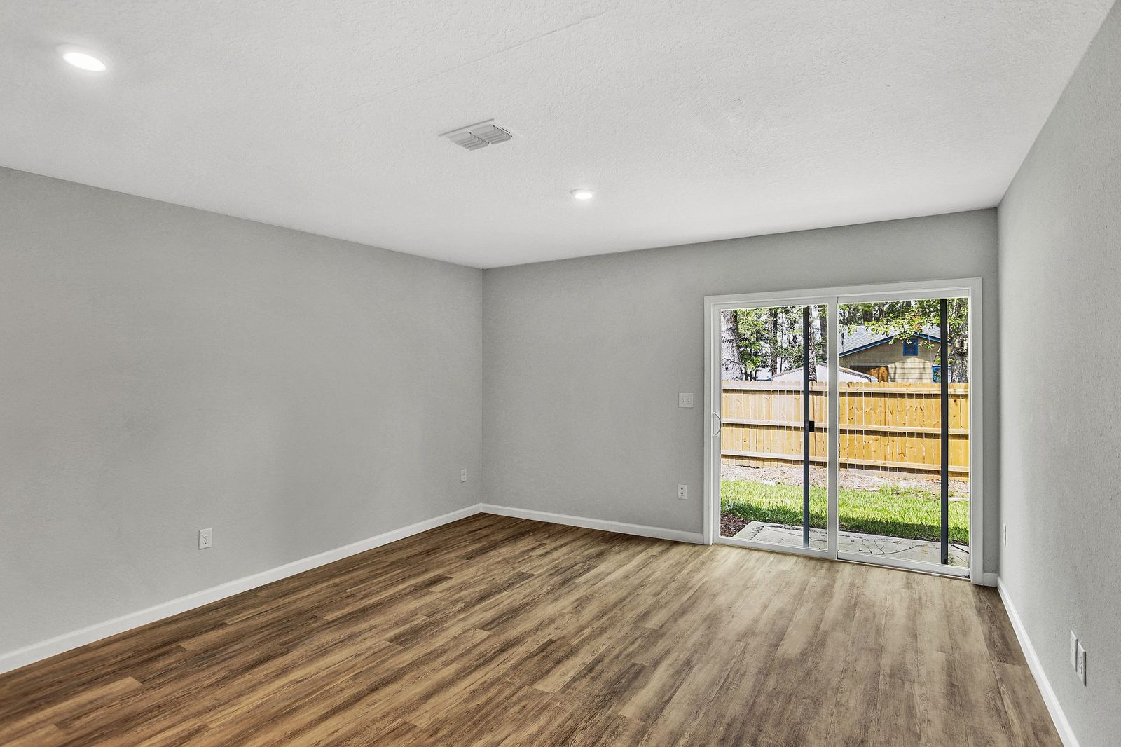 Living room with sliding glass door to the patio and fenced yard at Morgan's Walk