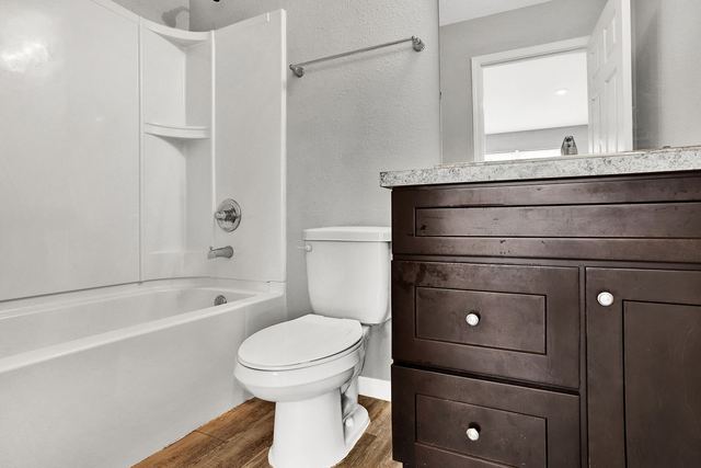 Full bath with tub and dark vanity